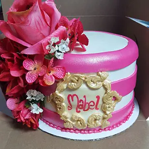 A pink cake covered in roses