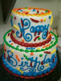 A rainbow Happy Birthday tiered cake
