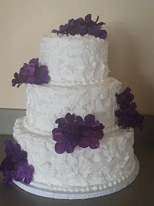 White ruffle cake with purple flowers