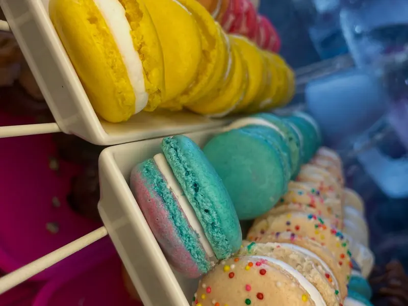 Stacks of pastel macarons in yellow, teal, pink, and sprinkles